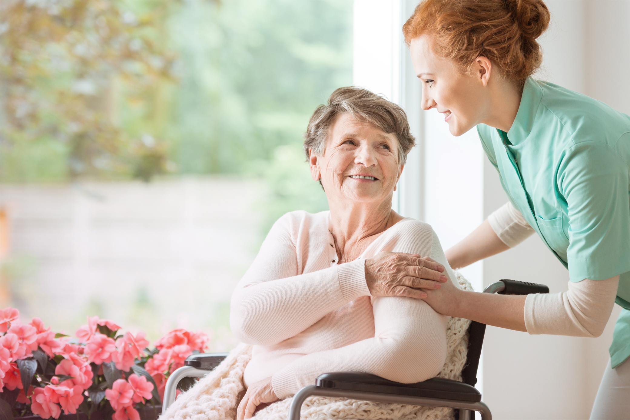 Pflegekraft kümmert sich um Seniorin